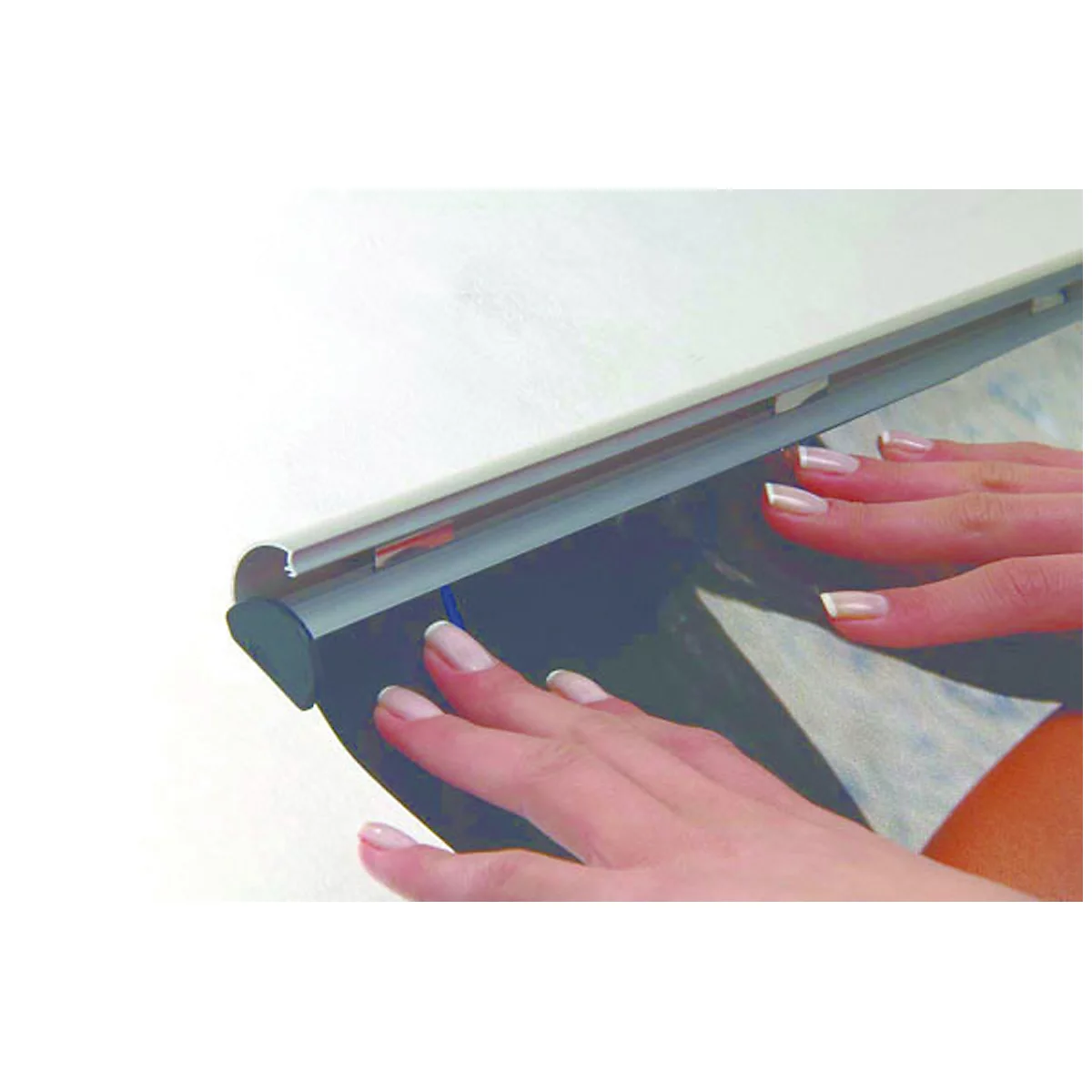 Hände halten ein Poster fest, das an einer Klemmleiste befestigt ist.