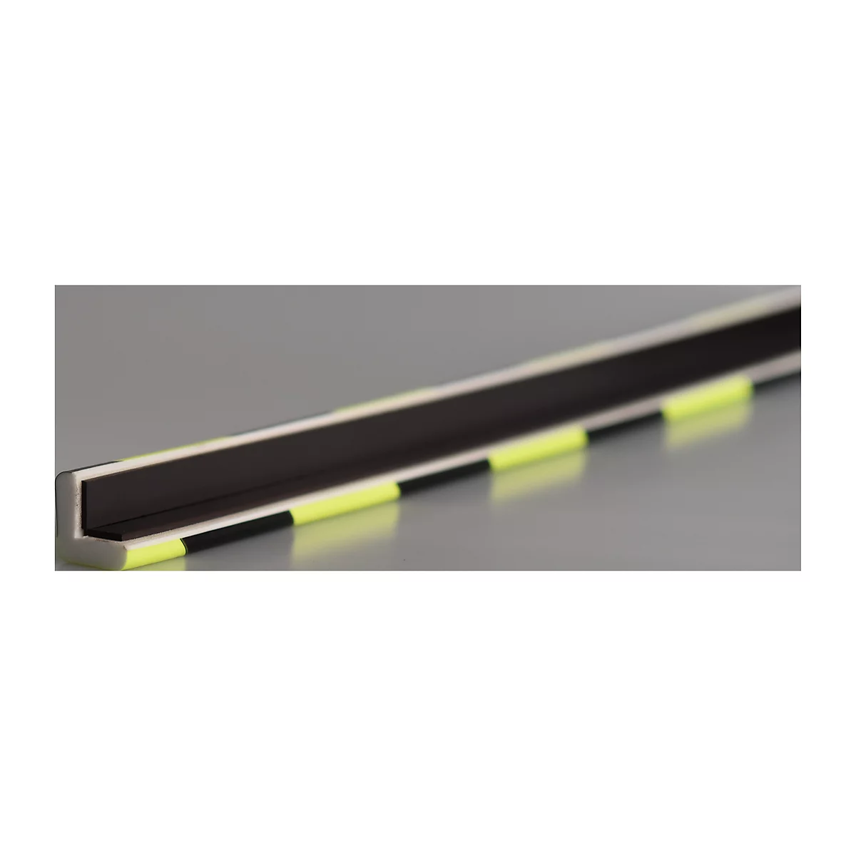 Close-up of an L-shaped bar with yellow markings. It lies on a gray background.