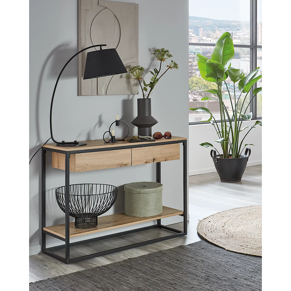 Konsole mit Holzplatte, Metallrahmen, Lampe, Vase, Dekoration und Pflanze. Im Hintergrund Fenster mit Stadtblick.
