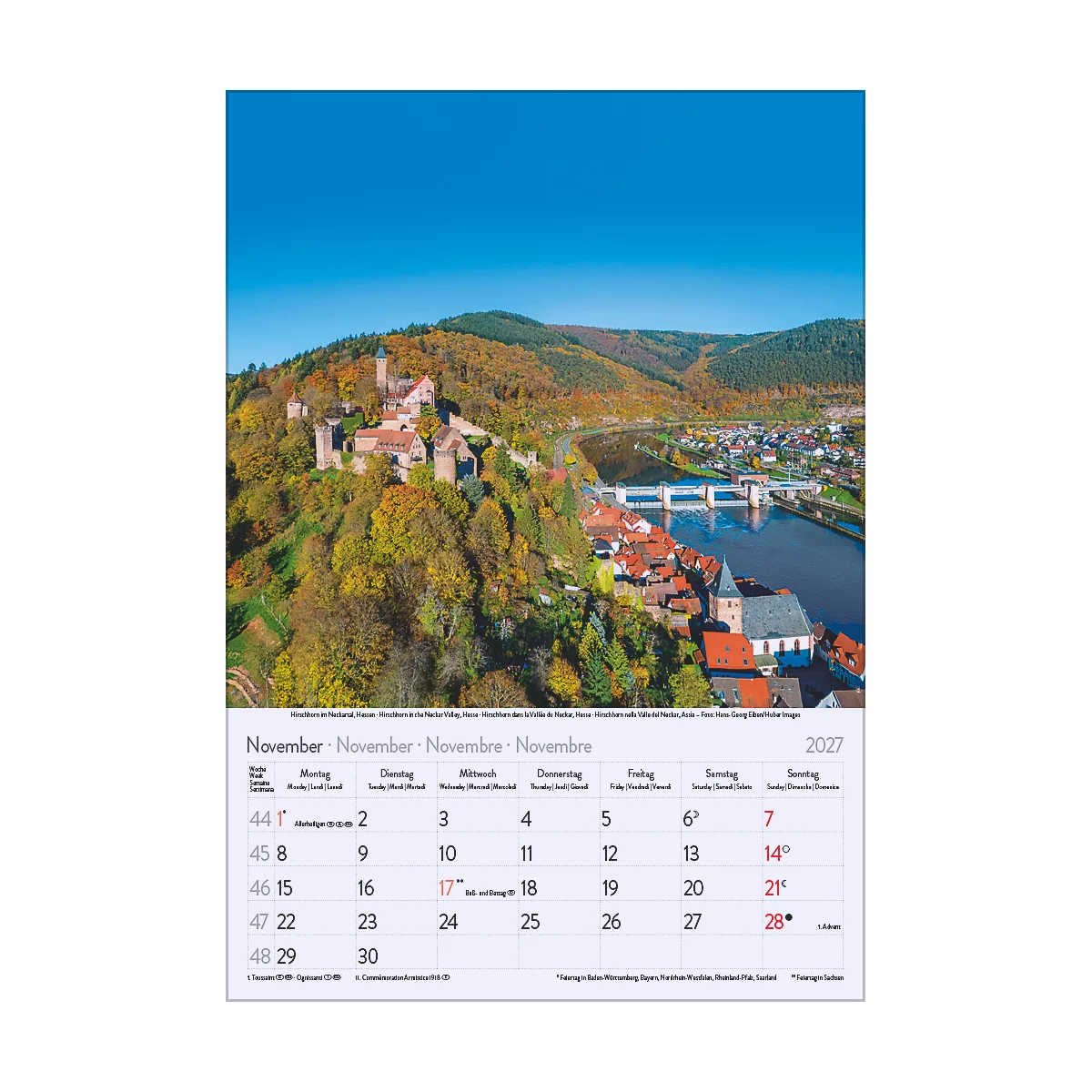 Calendrier montrant un château sur une colline avec des arbres colorés, une rivière et une ville.