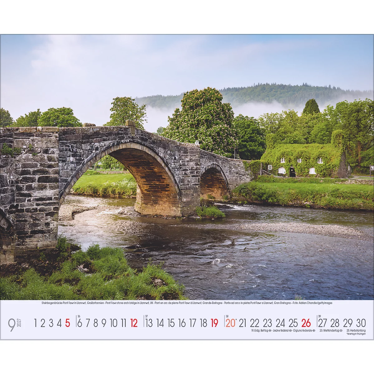Pont en arc en pierre au-dessus d'une rivière. Sur la berge, une maison couverte de lierre. En arrière-plan, une montagne dans le brouillard.