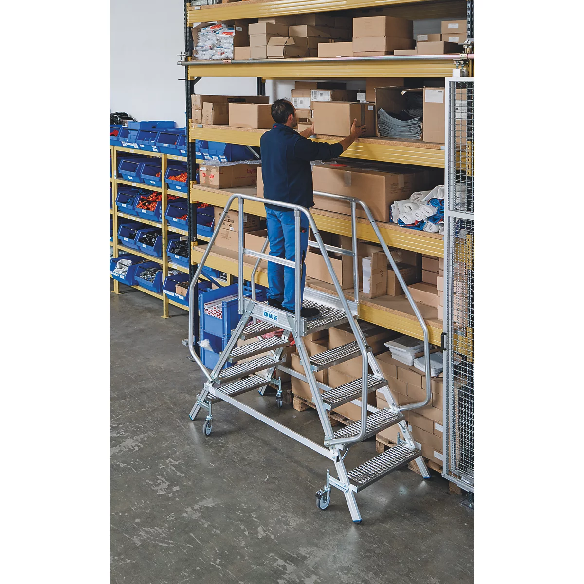 Man op een trap inspecteert schappen met dozen in een magazijn.