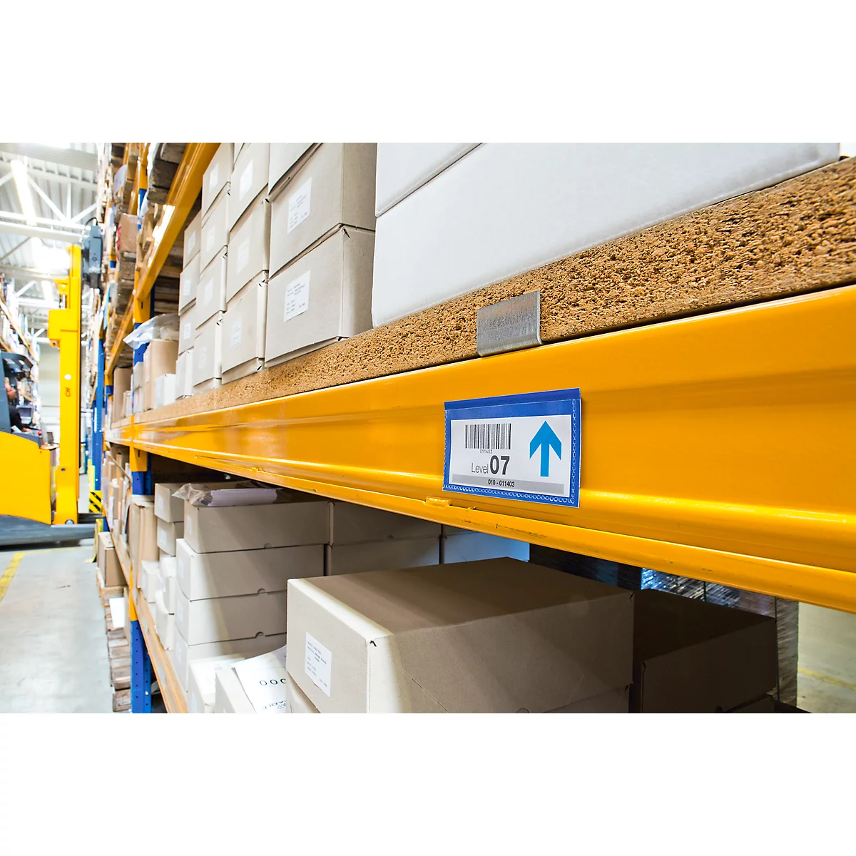 Yellow shelves with boxes, shelf label with up arrow and number 07.