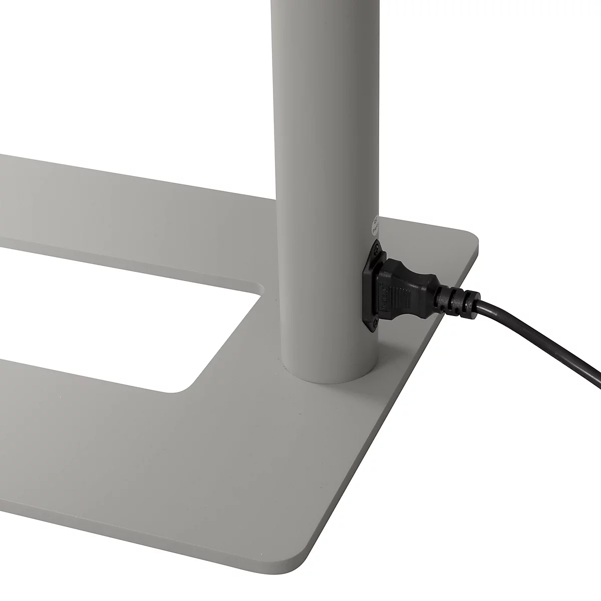 Gros plan : connecteur d'alimentation sur une structure métallique grise. Un cordon d'alimentation noir est branché.