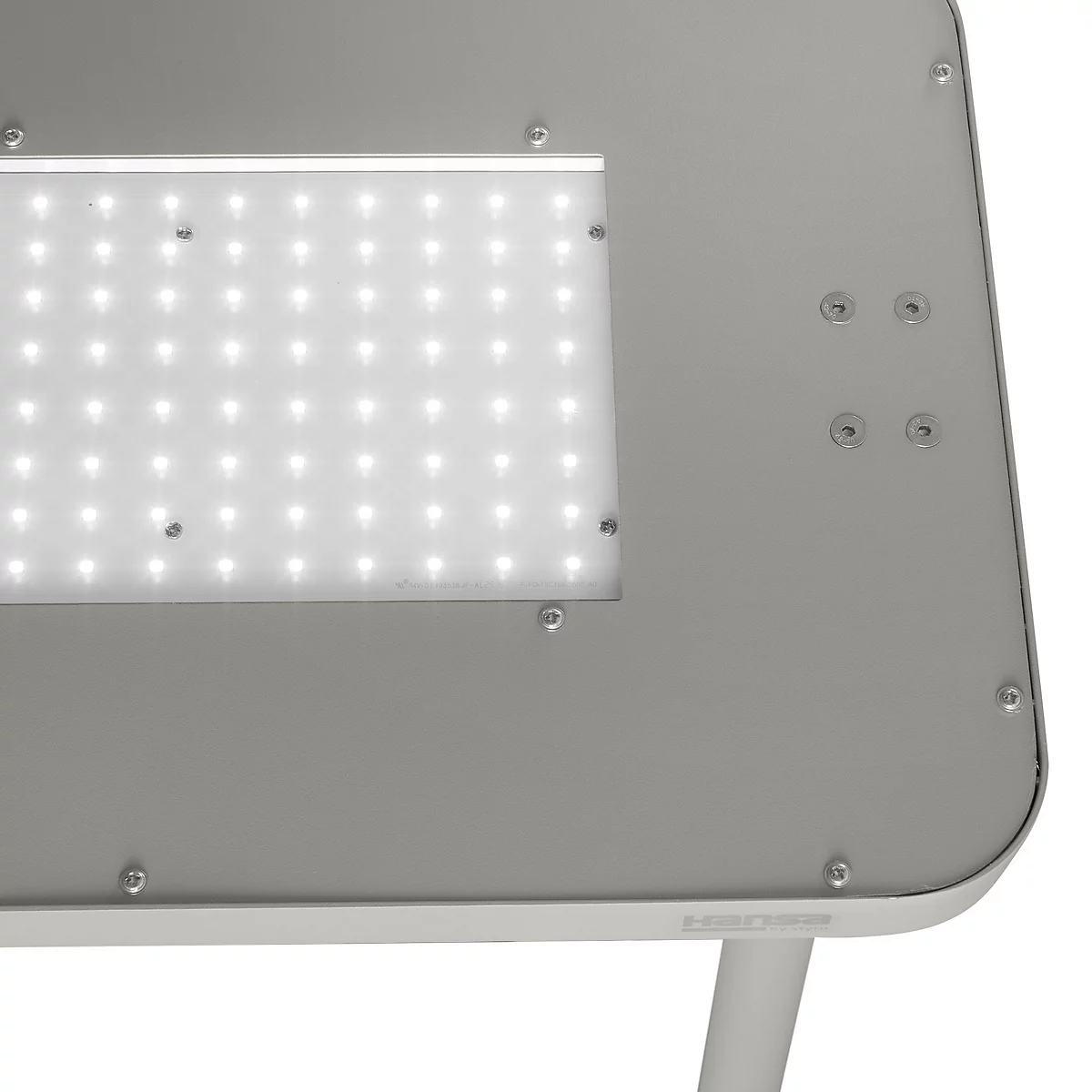 Gros plan sur une lampe LED avec une surface argentée, composée de nombreuses petites LED. Le design est moderne et minimaliste.
