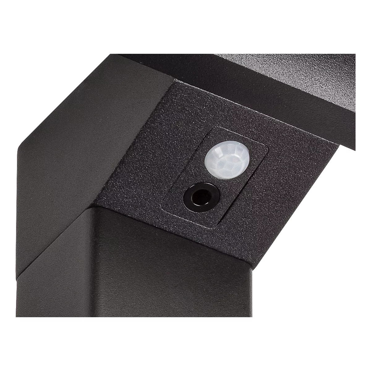 Gros plan : Coin noir avec détecteur de mouvement et trou, probablement une partie d'une lampe extérieure.