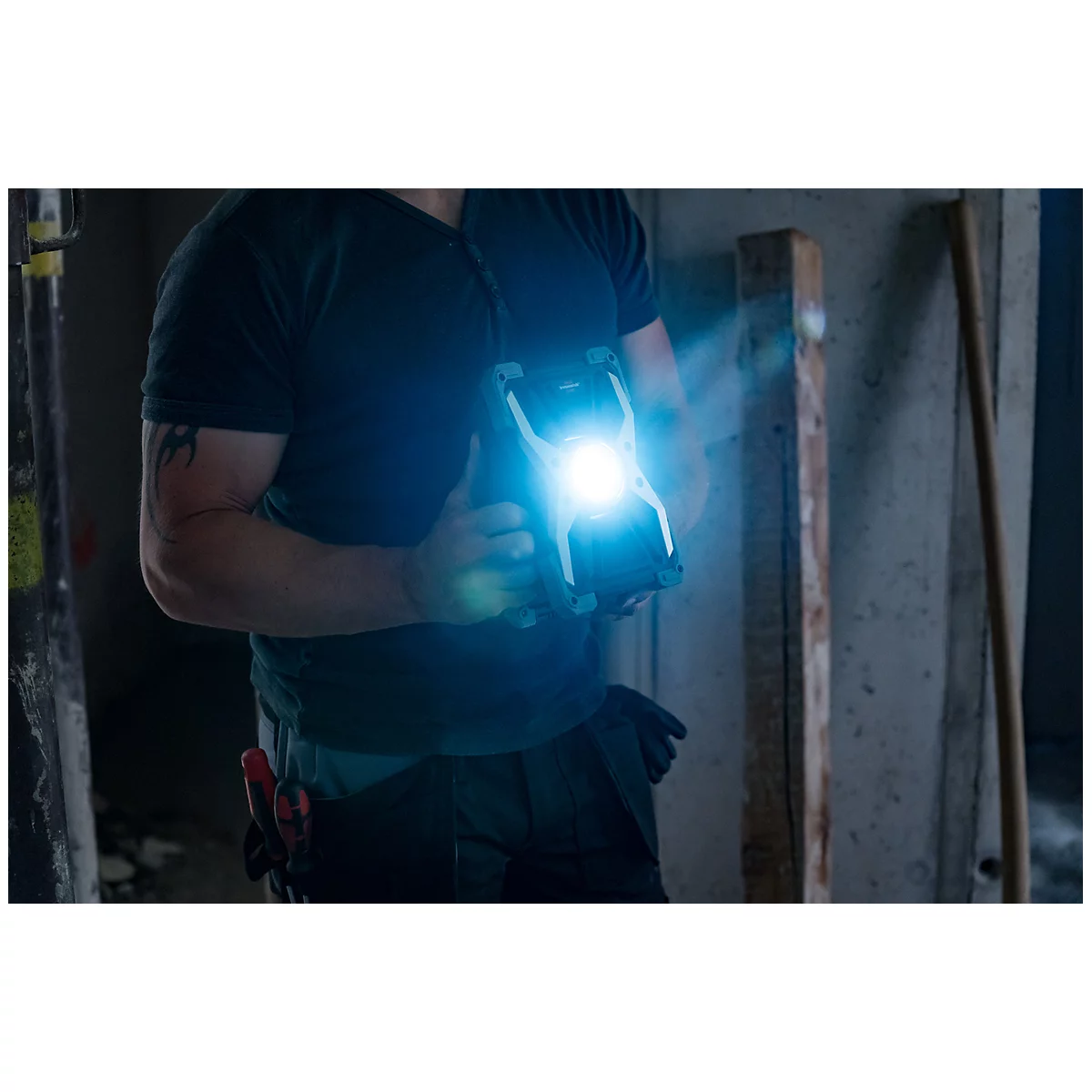 Tragbare LED-Arbeitslampe mit schwarzem und silbernem Gehäuse, rundem Lichtmittel in der Mitte.