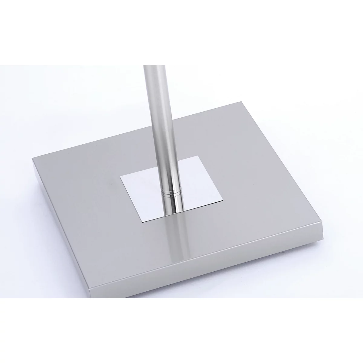 Close-up of a metal stand base plate with an embedded pole.