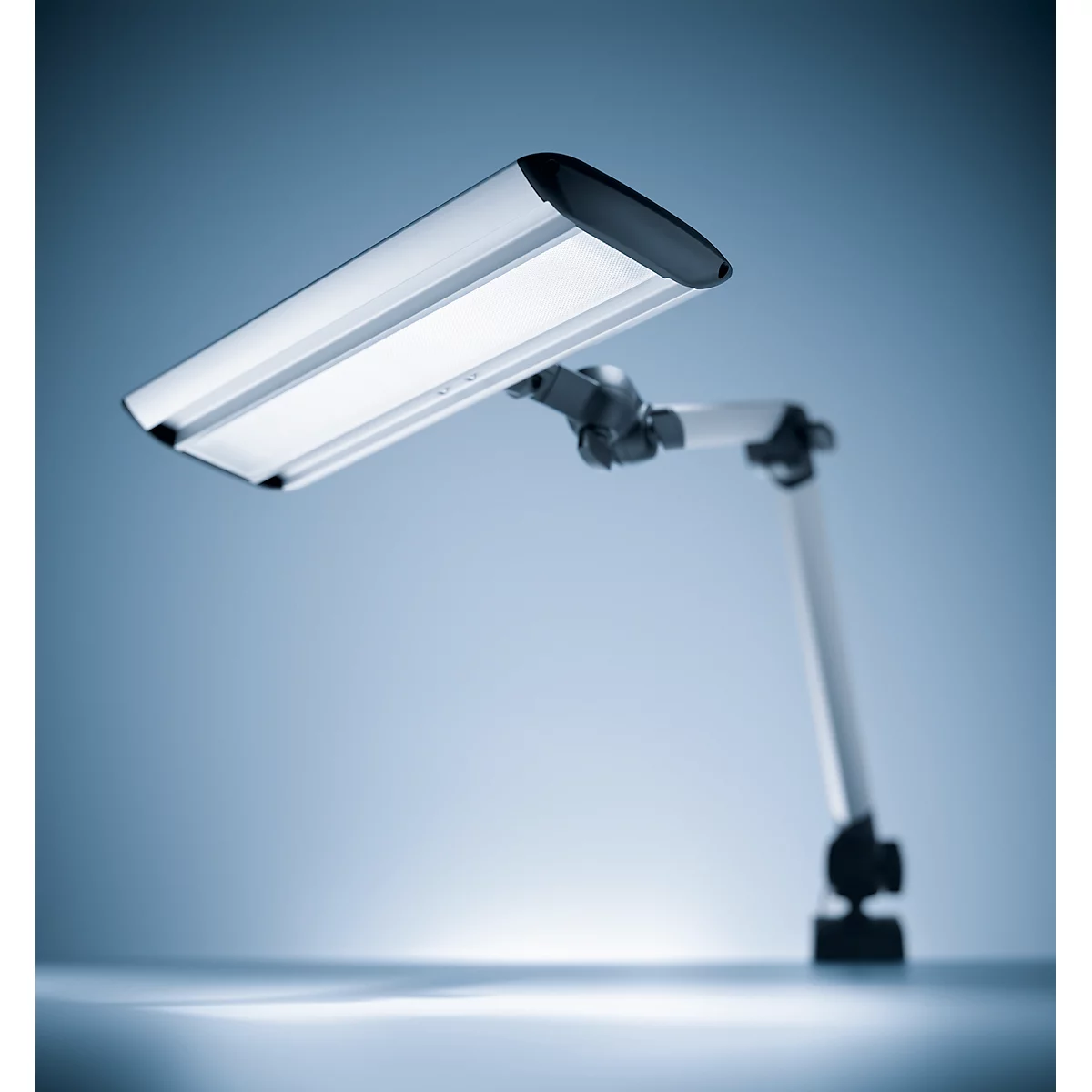 A modern desk lamp. The lamp head is rectangular and silver with a black top. The flexible arm is also silver.