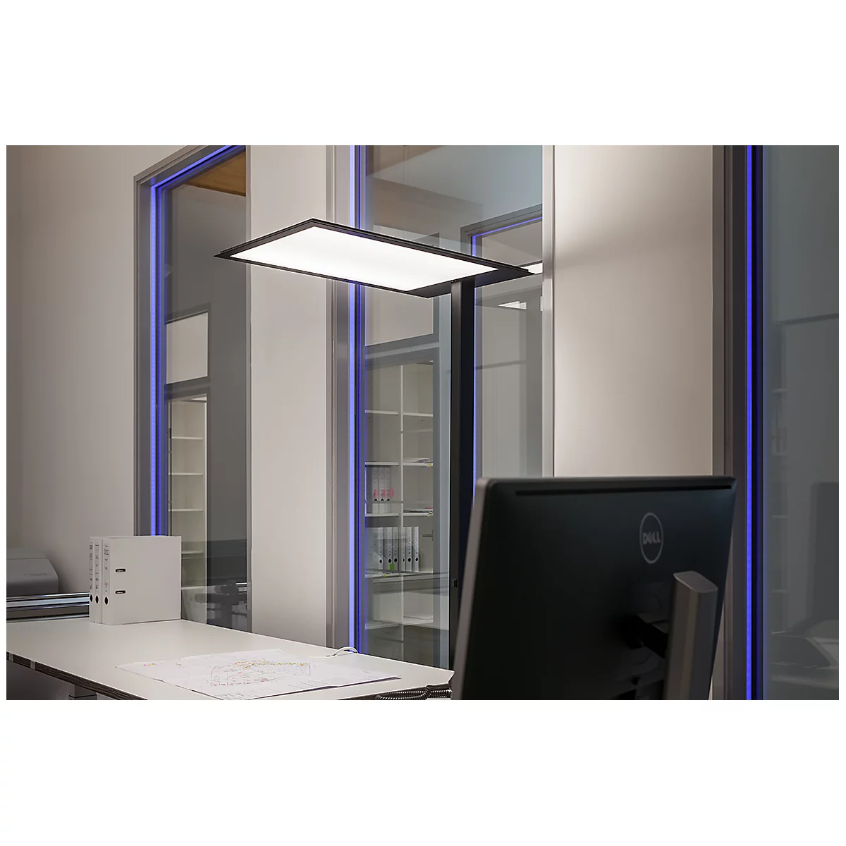 Bureaulamp die een bureau verlicht, computerscherm op de voorgrond.