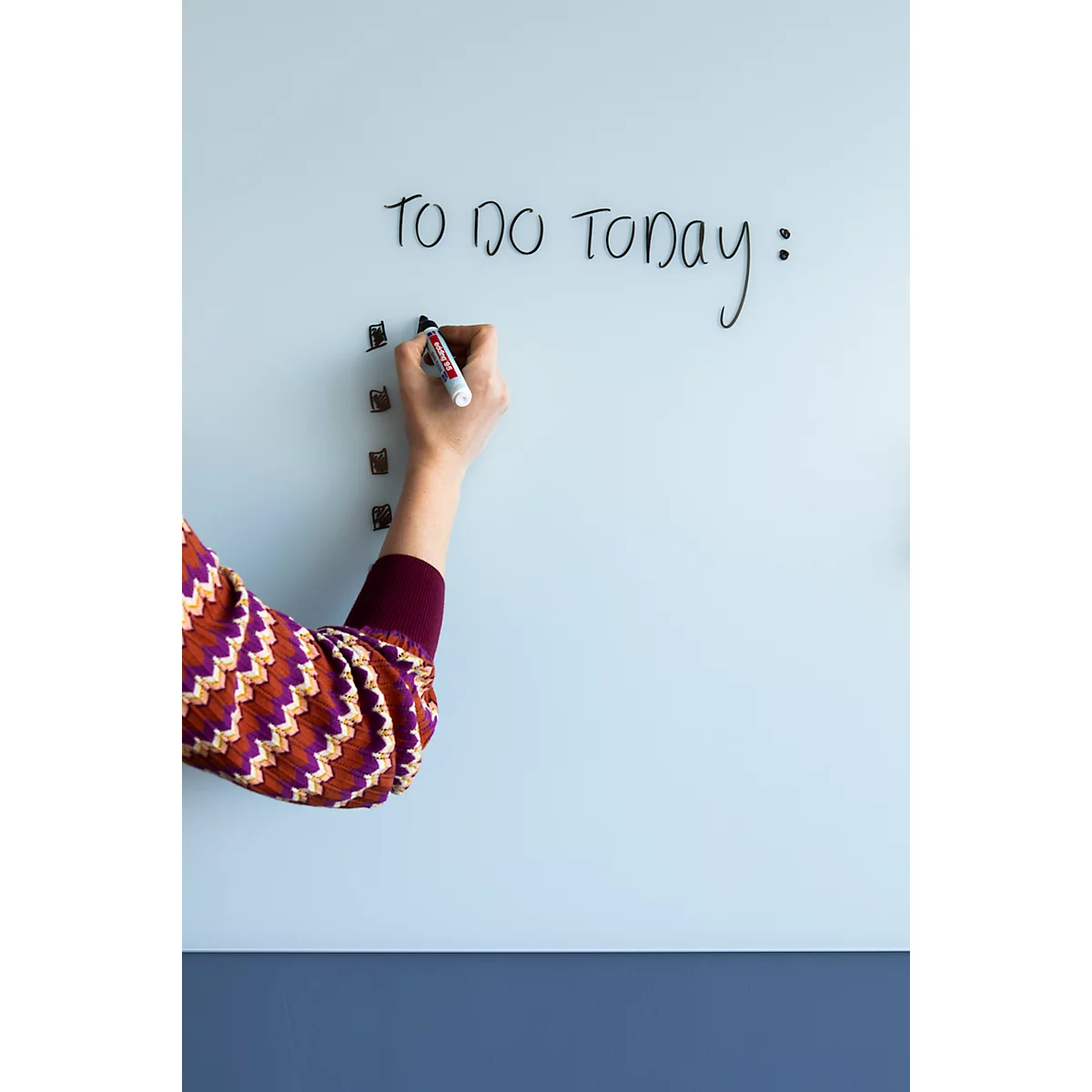 Une personne écrit 'TO DO TODAY:' sur un tableau blanc avec un marqueur noir.