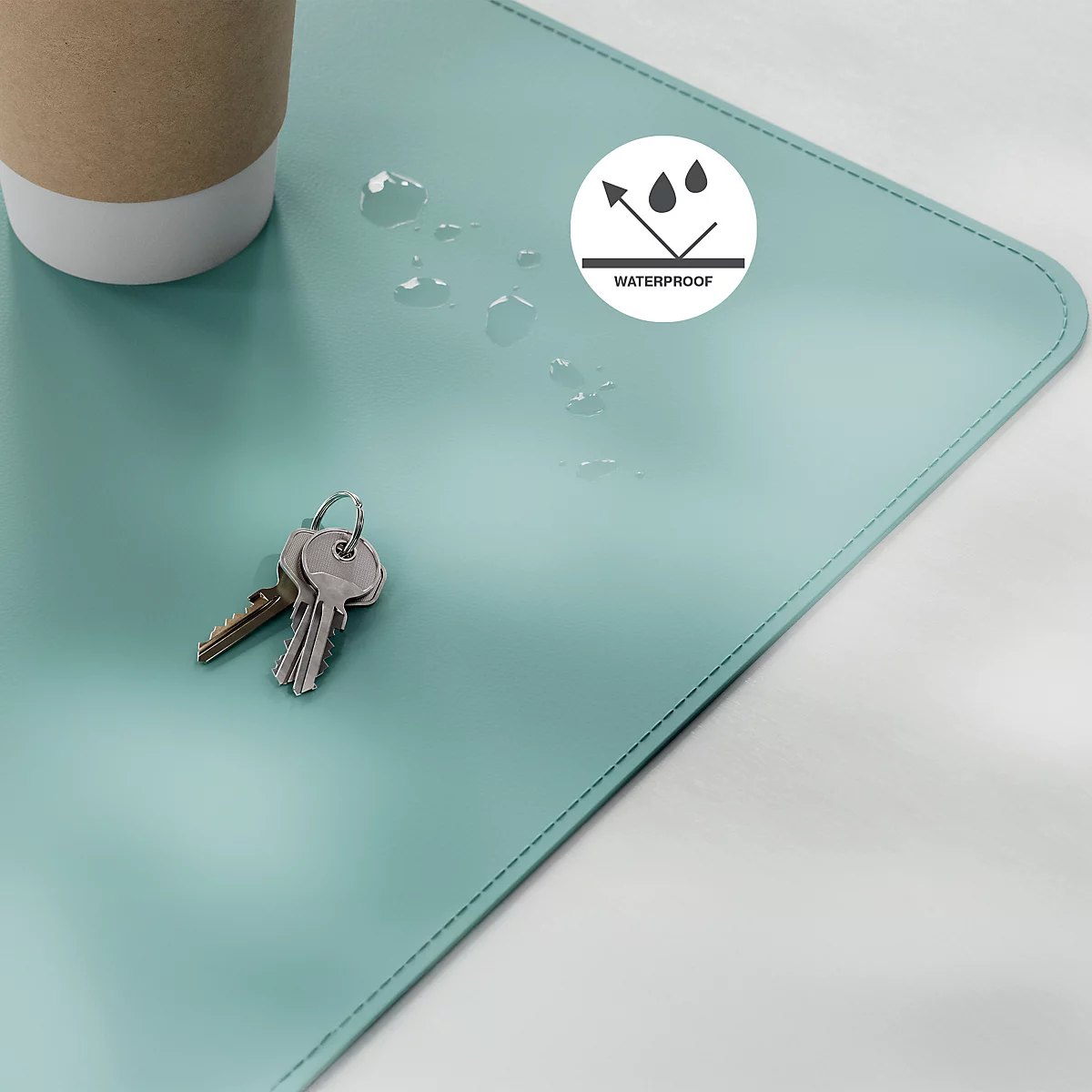 Lichtblau bureau-onderlegger, sleutels, koffiebeker, druppels, het symbool "waterproof".