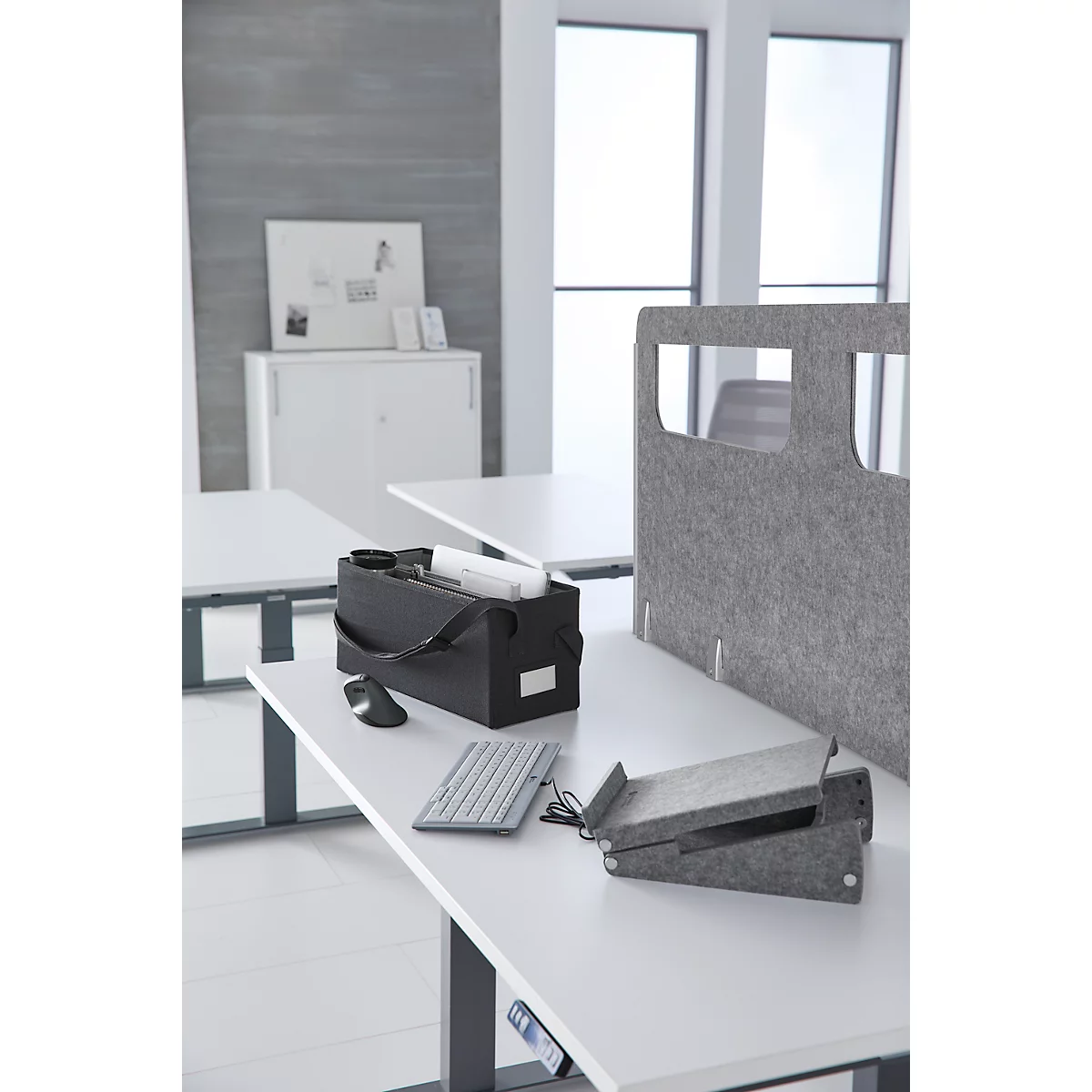 Büro mit Schreibtisch, Computerzubehör und Filztrennwänden.