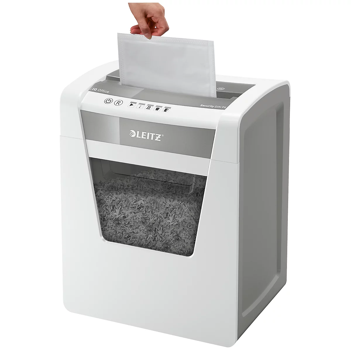 A hand feeds paper into a white Leitz shredder. The collection bin is full.