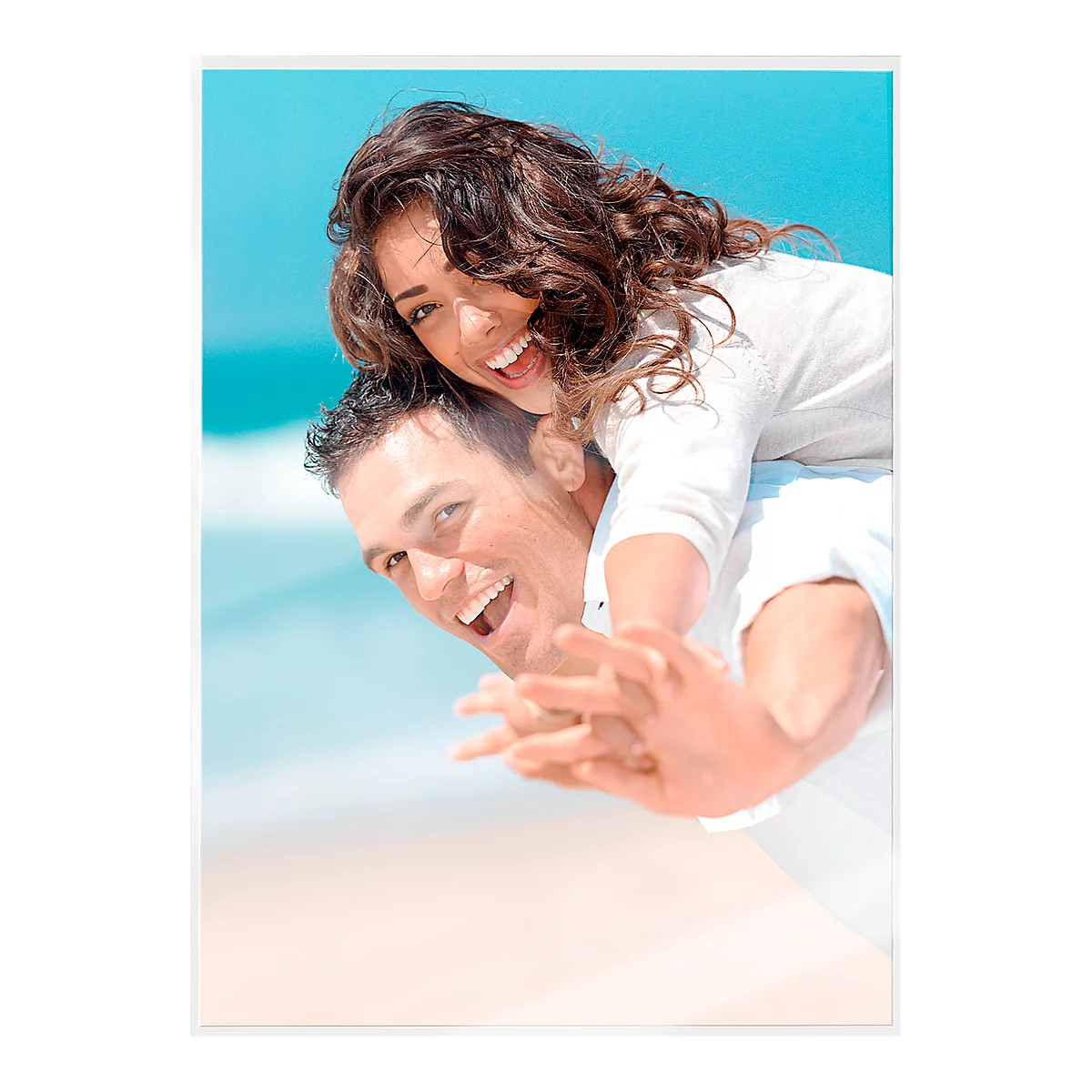 Happy couple at the beach: Man carries laughing woman on his shoulders.