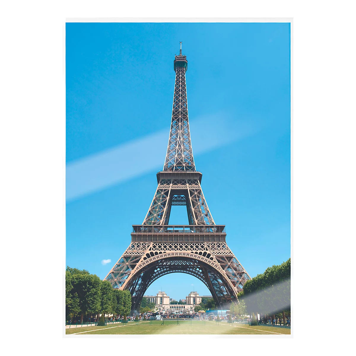 Eiffel Tower in Paris. Blue sky, green trees at the base.