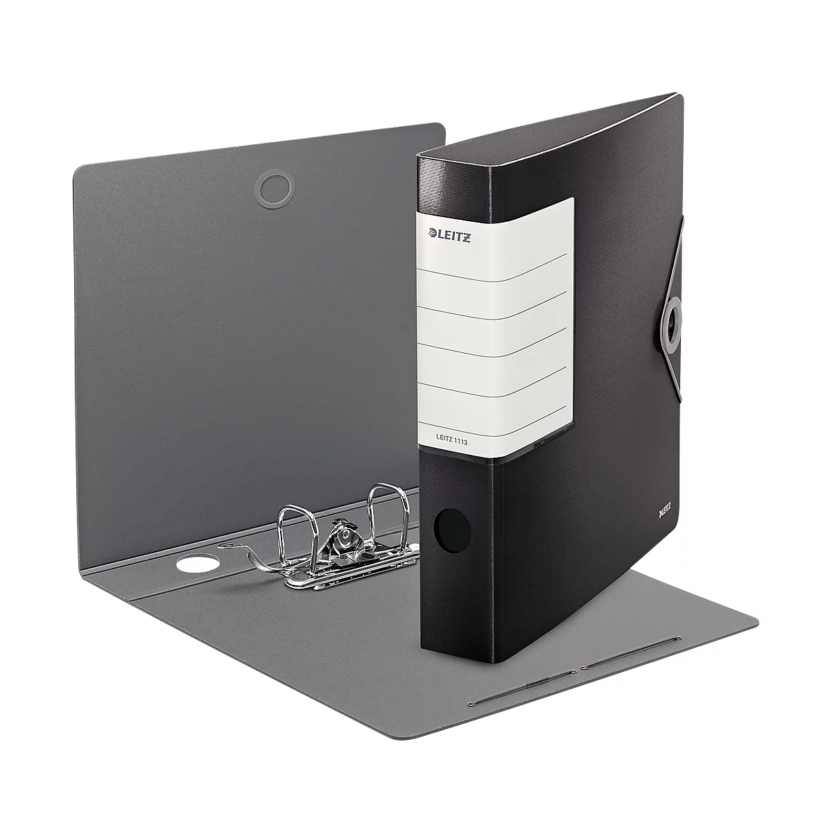 A black Leitz binder stands open. The gray inside can be seen, with ring mechanism. A white label with lettering is attached.
