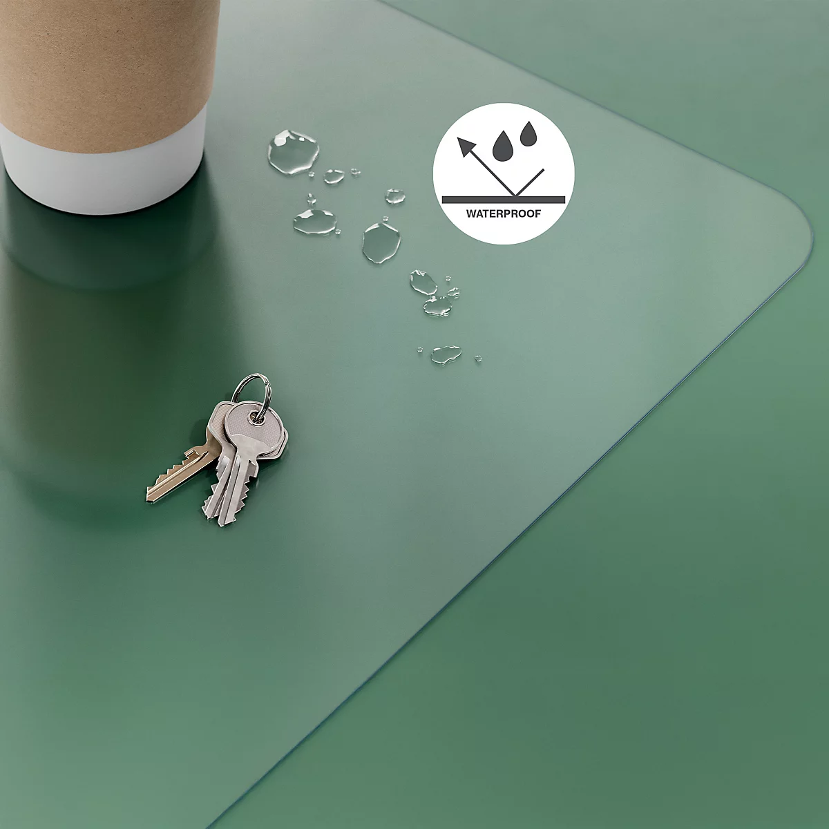 Tapis de bureau vert et imperméable avec trousseau de clés, gobelet en papier et gouttes d'eau.