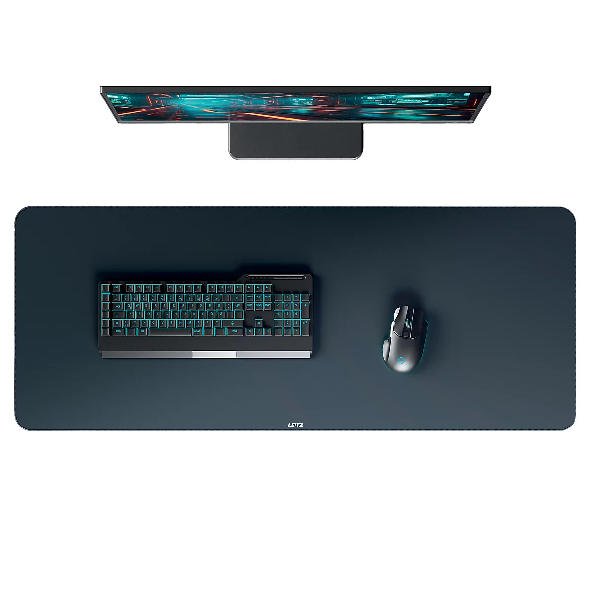 Clavier, souris et écran gris foncé sur un grand tapis de bureau sombre.