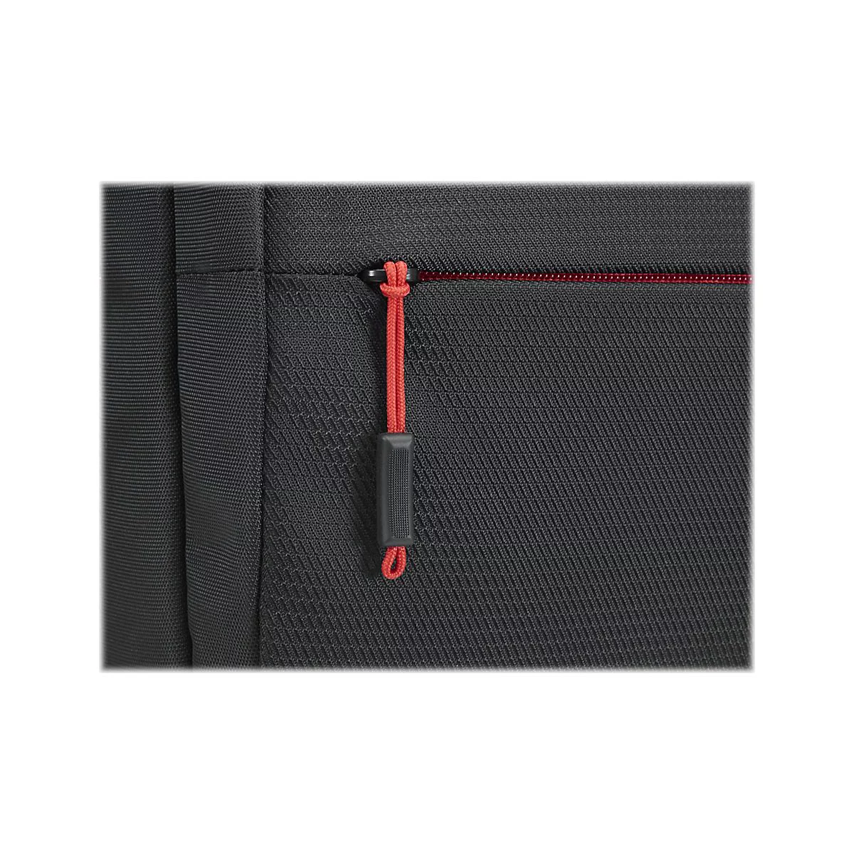 Gros plan d'un sac noir avec fermeture éclair et tirette rouges. La matière a une texture fine.