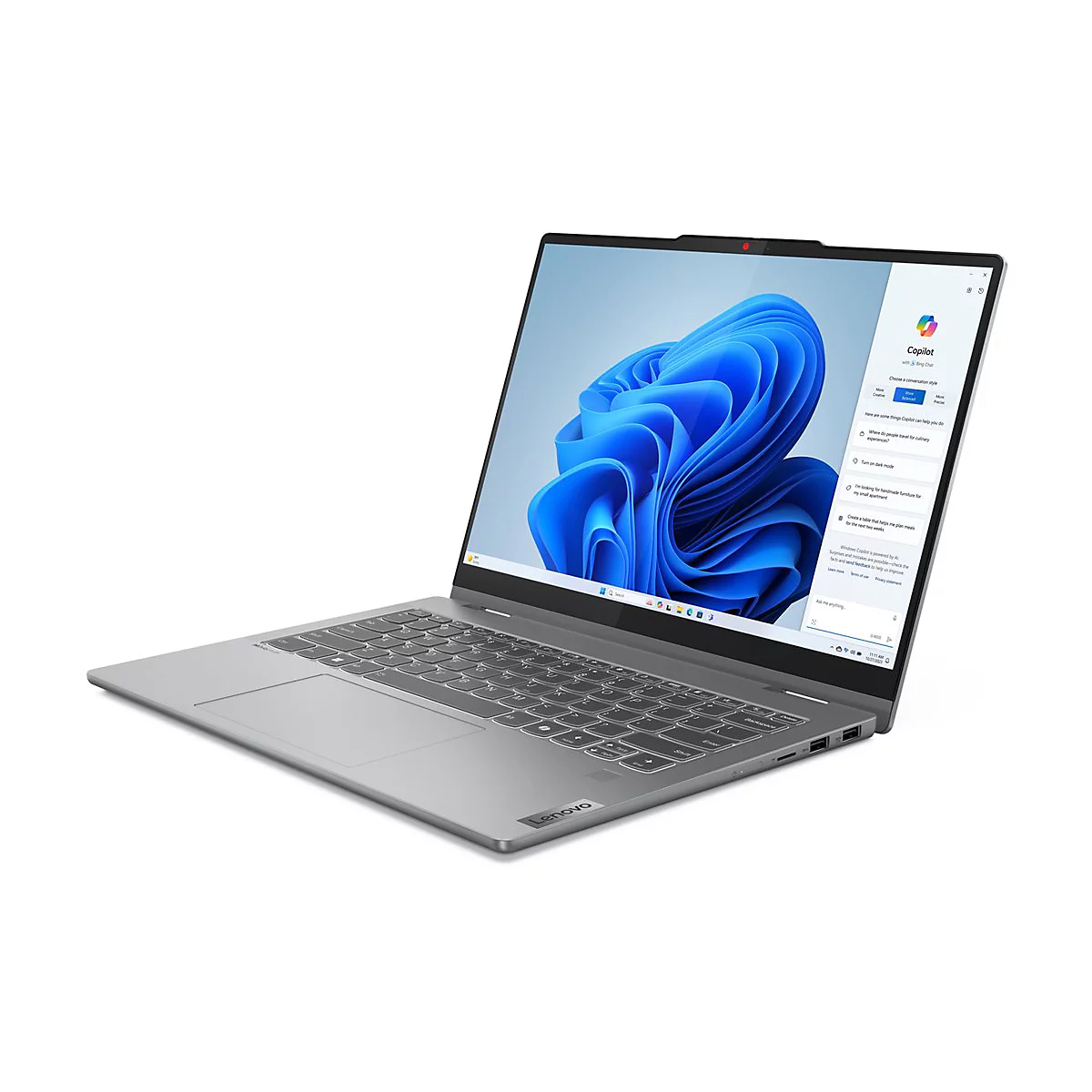 Graues Lenovo-Laptop mit geöffnetem Bildschirm, der Copilot zeigt. Die Tastatur ist sichtbar, das Gerät ist auf einem weißen Hintergrund.
