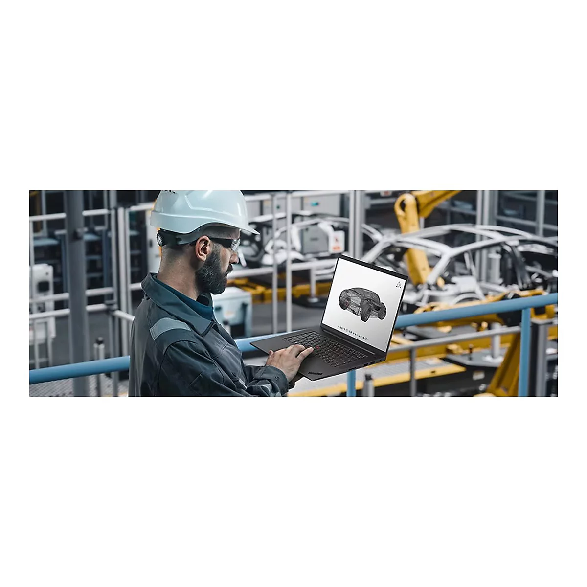 Ein Mann in Schutzkleidung und Helm betrachtet am Laptop ein 3D-Autodesign in einer Fabrik.