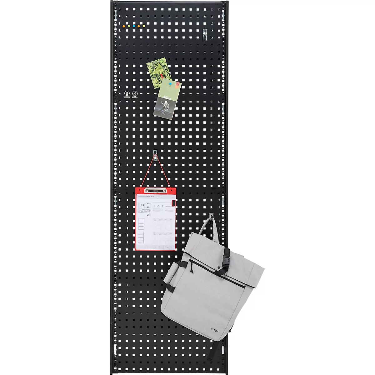 Schwarze Lochwand mit Zetteln, Notizblock und helle Tasche. Die Lochwand hat quadratische Löcher. Zettel und Notizblock werden mit Klammern und Haken befestigt.