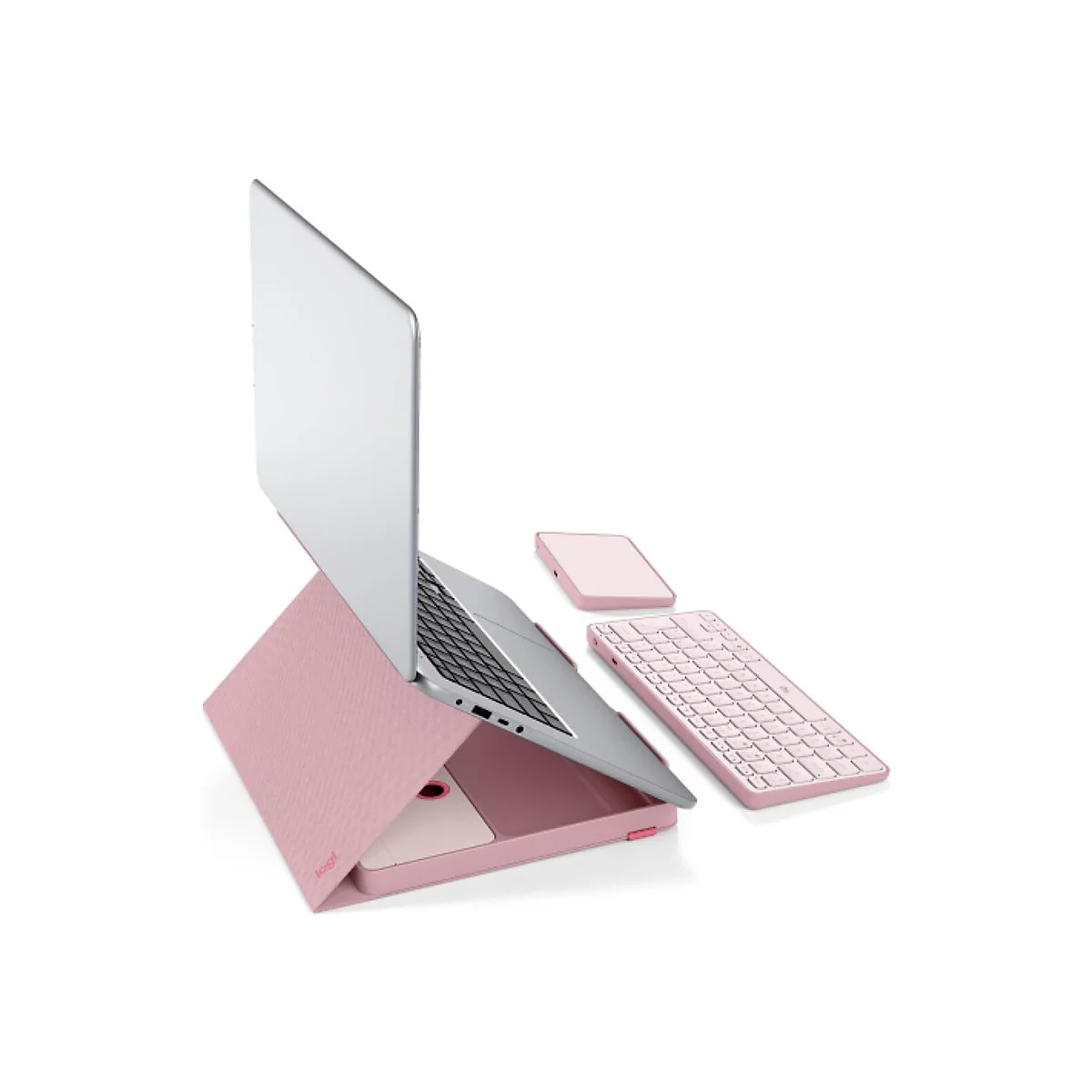 Ein rosa Laptop steht auf einer Hülle mit Tastatur, Maus, hellem Hintergrund. Das Logo "Logi" ist zu sehen.