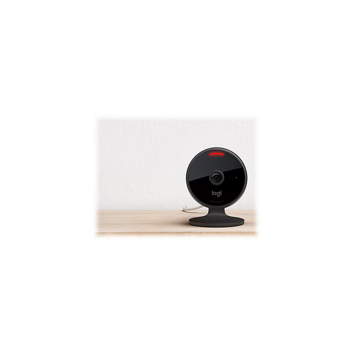 Schwarze Ãœberwachungskamera mit roter Leuchte. Auf Tisch vor weiÃŸer Wand. Marke: Logi.