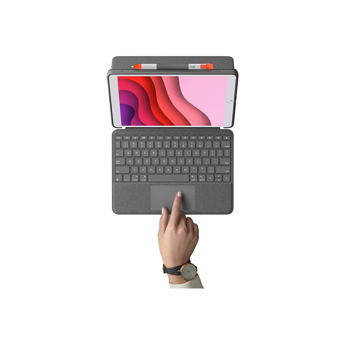 Draufsicht auf Tablet mit Tastatur, Stiften und Hand mit Uhr. Der Finger berÃ¼hrt das Trackpad.