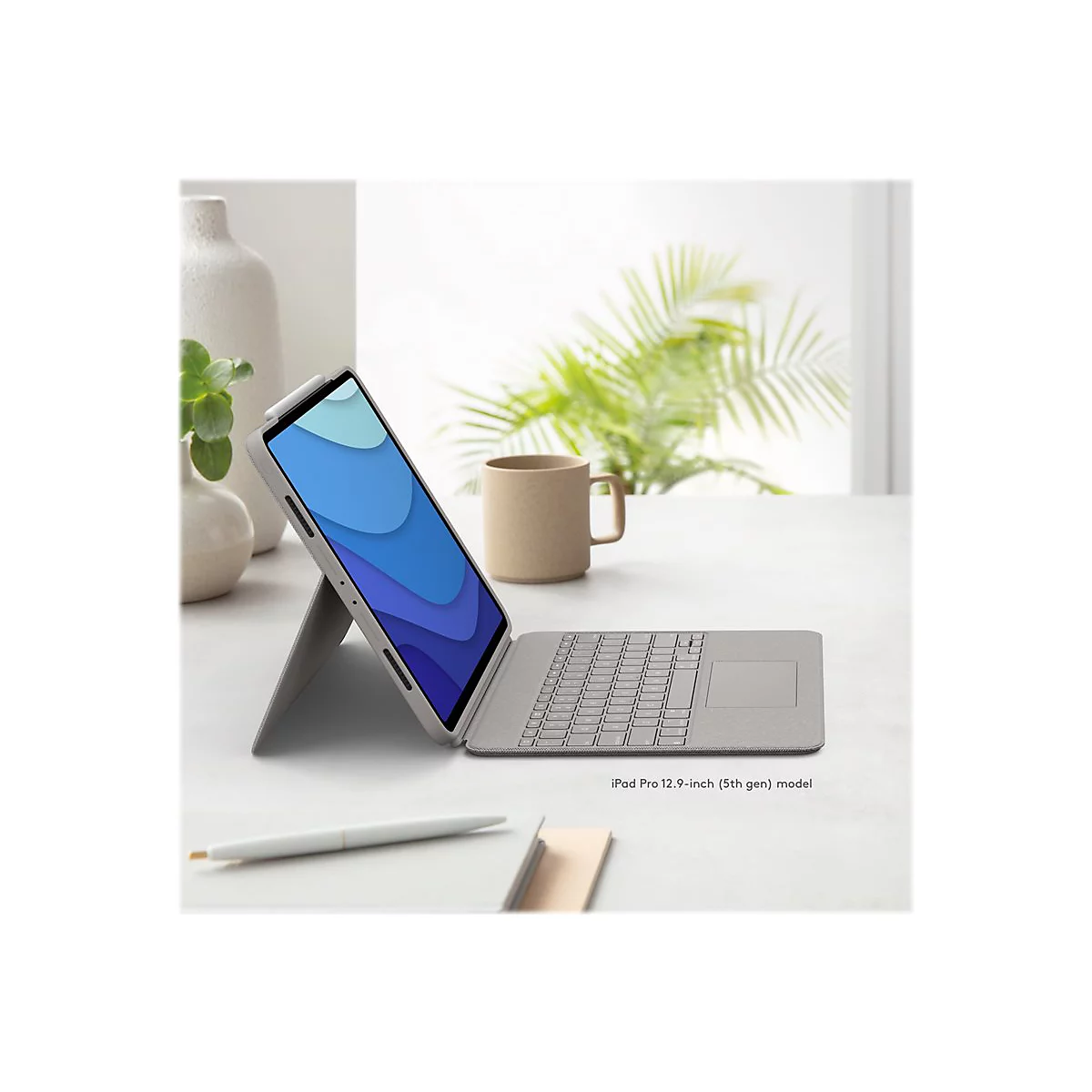 Ein Tablet mit Tastatur liegt auf einem weiÃŸen Tisch. Auf dem Bildschirm ist ein blauer Hintergrund zu sehen.