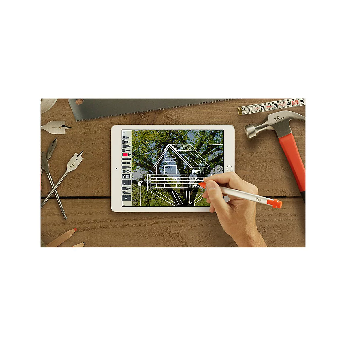 Tablette avec plan de construction entourÃ©e d'outils, main dessinant avec un stylo.