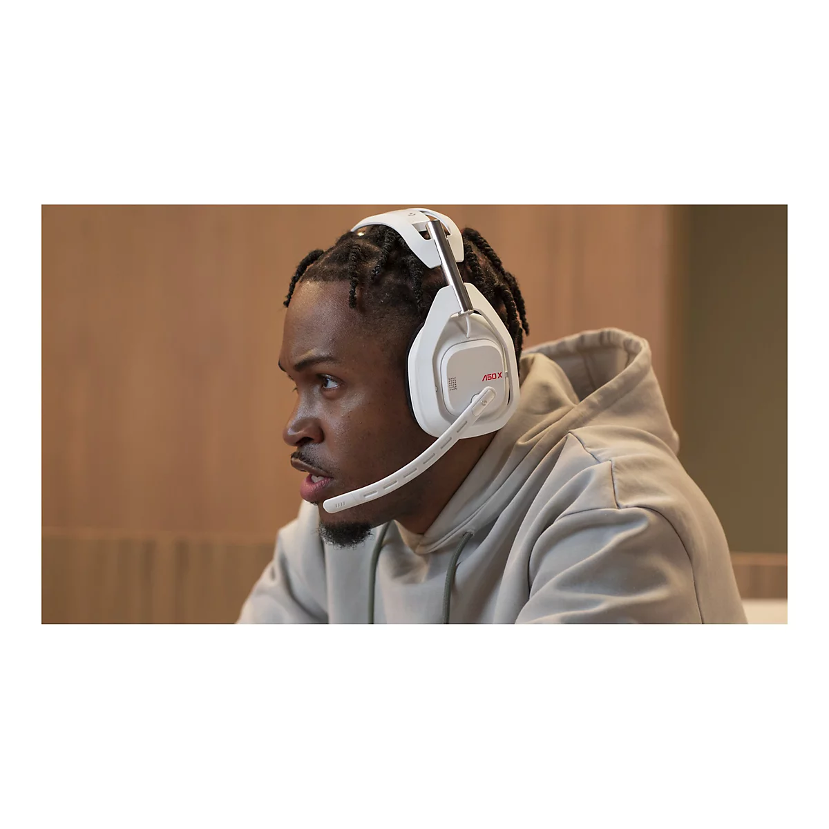 Ein Mann trÃ¤gt ein weiÃŸes Gaming-Headset und schaut konzentriert nach rechts.