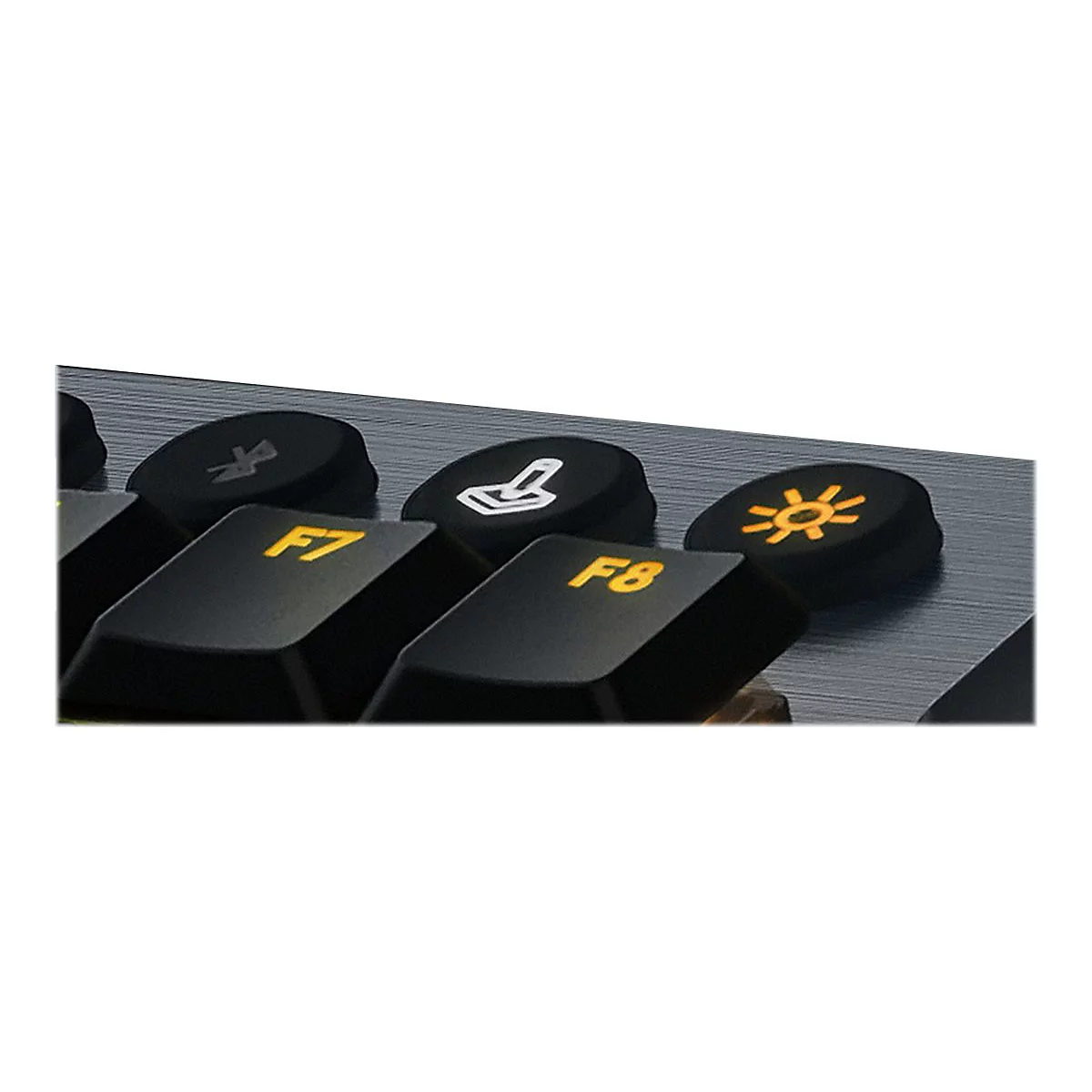 Nahaufnahme einer schwarzen Tastatur, die F7 und F8-Tasten sind hervorgehoben. Auf anderen Tasten sind Symbole.