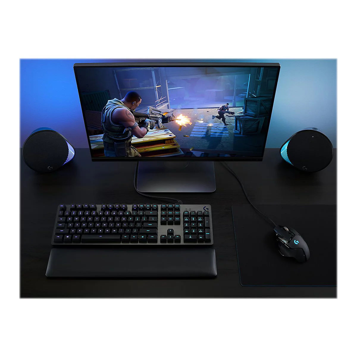 Ein Gaming-Setup mit Bildschirm, Tastatur, Maus und Lautsprechern. Auf dem Bildschirm ein Videospiel.