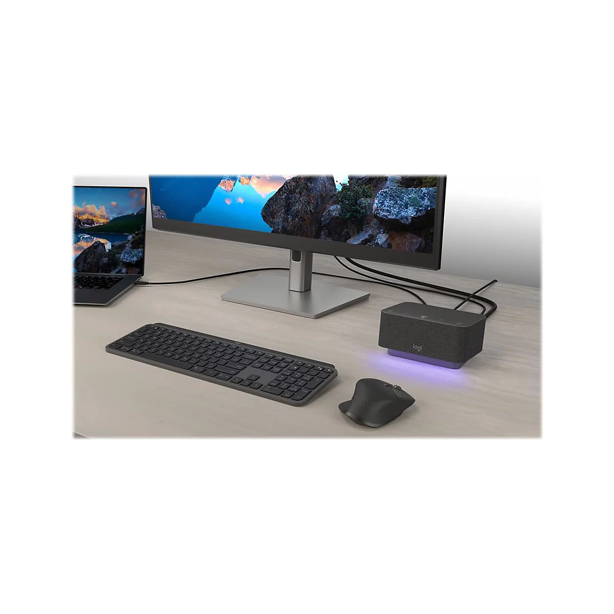 Schreibtisch mit Monitor, Tastatur, Maus, Laptop und einer Dockingstation. Das Logitech-Logo ist auf der Dockingstation zu sehen.