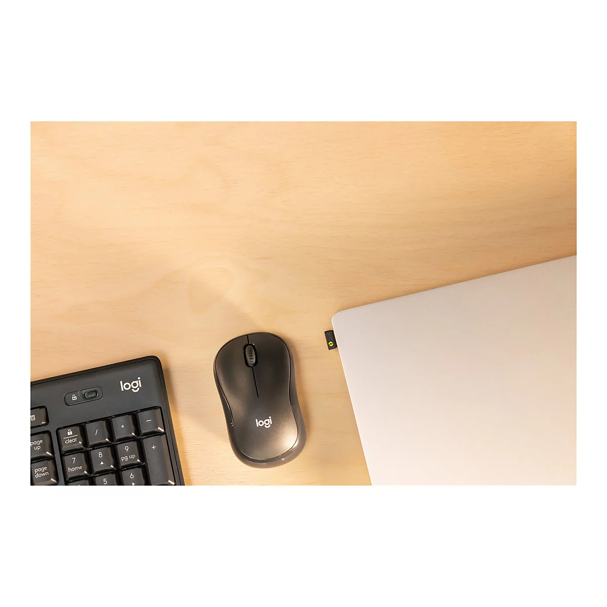 Draufsicht auf ein Laptop, Tastatur und Maus auf einer Holzoberfläche. Die Tastatur und Maus sind von Logitech.