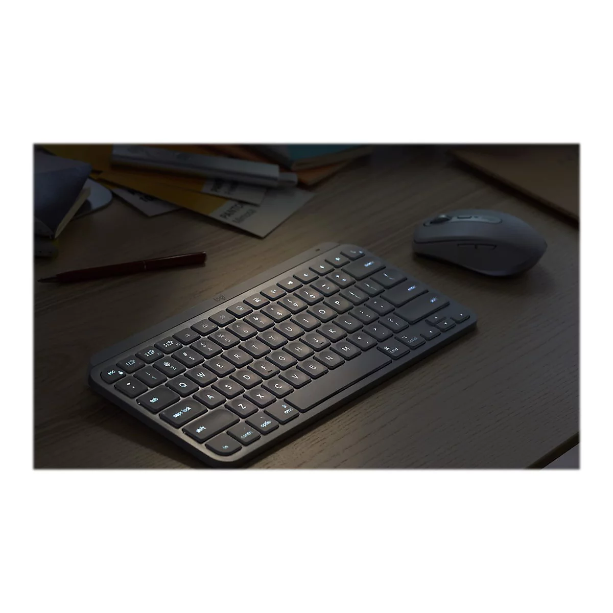 Draufsicht auf eine Tastatur, Maus und Notizen auf einem Schreibtisch. Helle Tasten beleuchten die Szene.