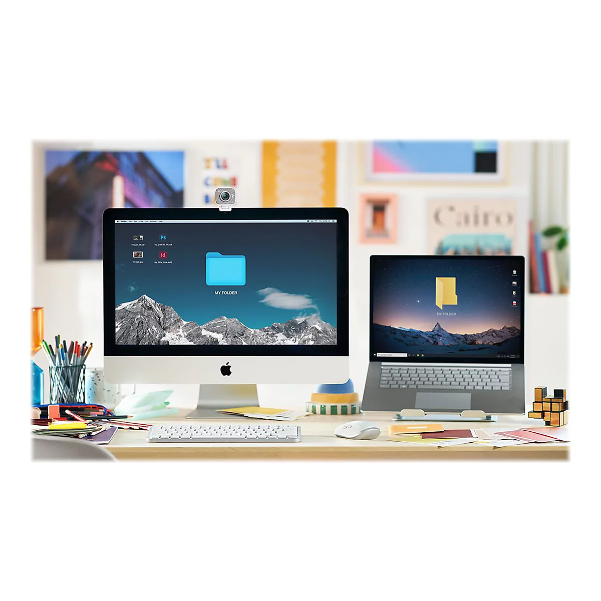 Ein Schreibtisch mit einem iMac und einem Laptop. Auf beiden Geräten ist ein blauer Ordner mit der Aufschrift "MY FOLDER" zu sehen.