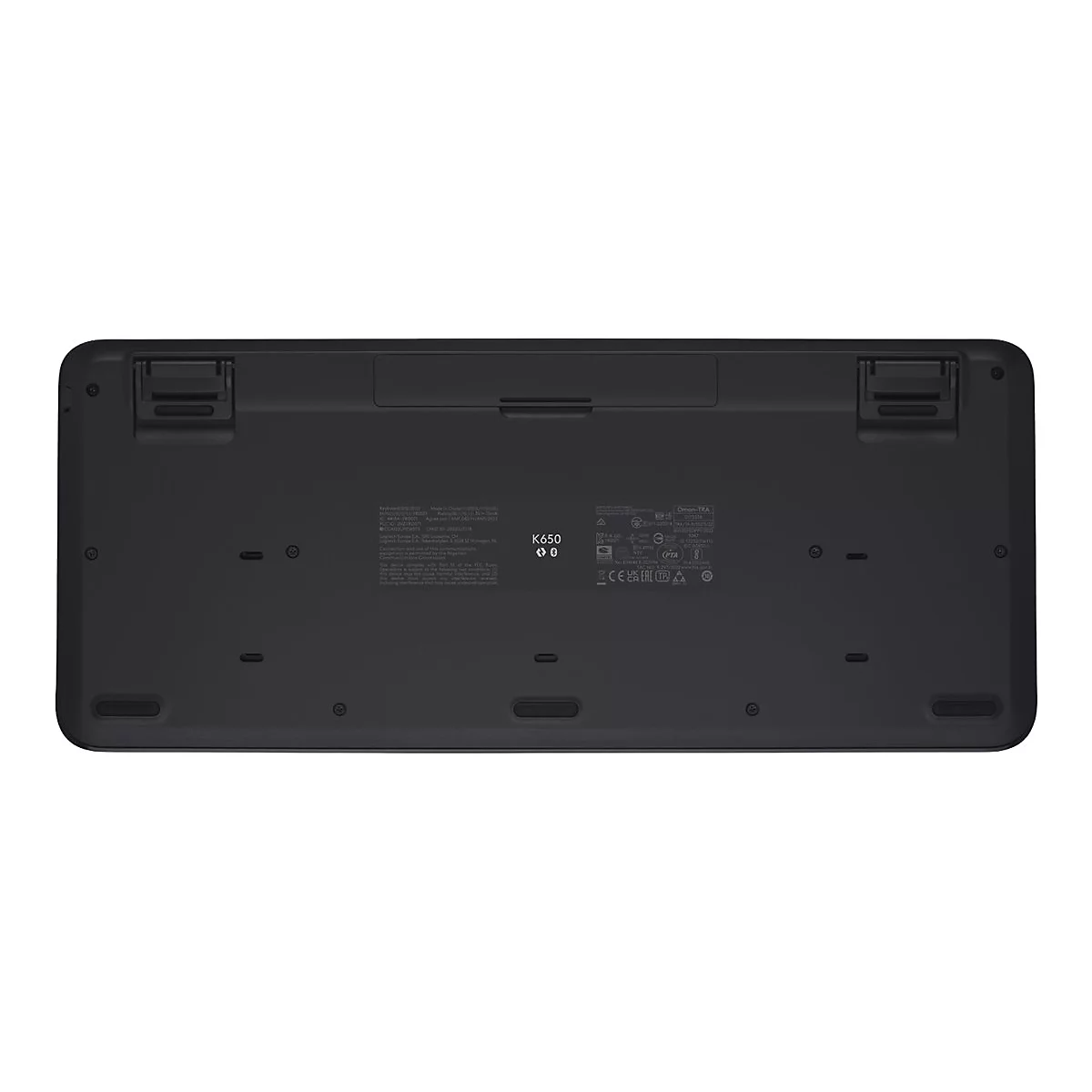 Die Unterseite einer schwarzen Logitech K650 Tastatur. Es gibt viele Kennzeichnungen und Stützfüße.