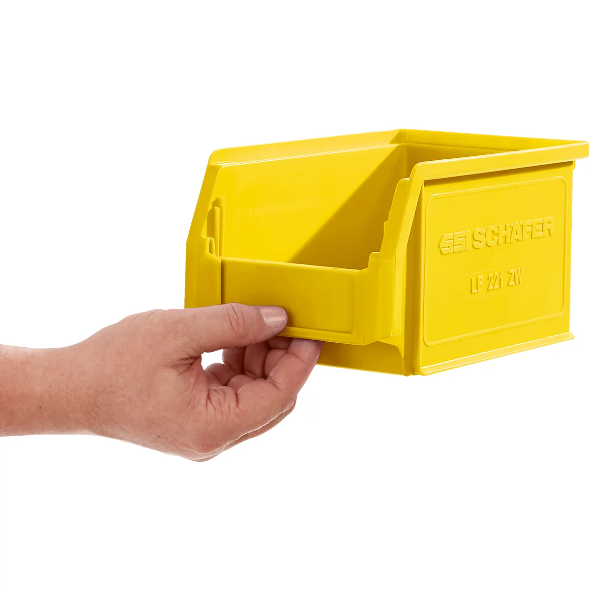 Een hand houdt een gele opslagbak van SSI Schaefer vast tegen een witte achtergrond.