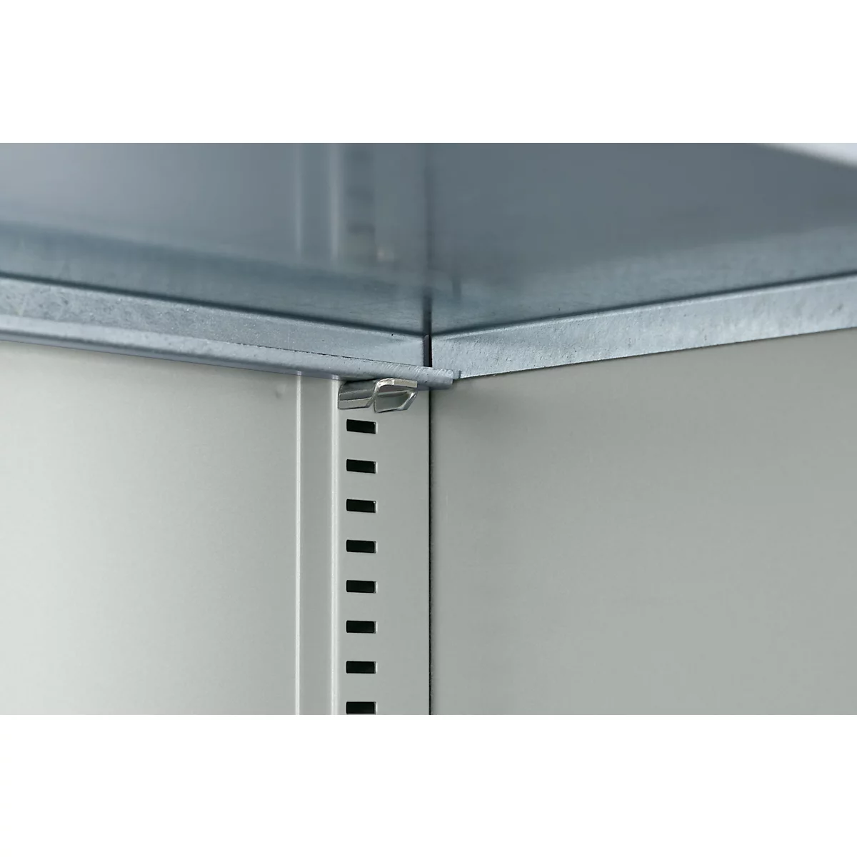 Nahaufnahme einer Ecke eines Metallschranks. Details der Verschraubung und Lochung.