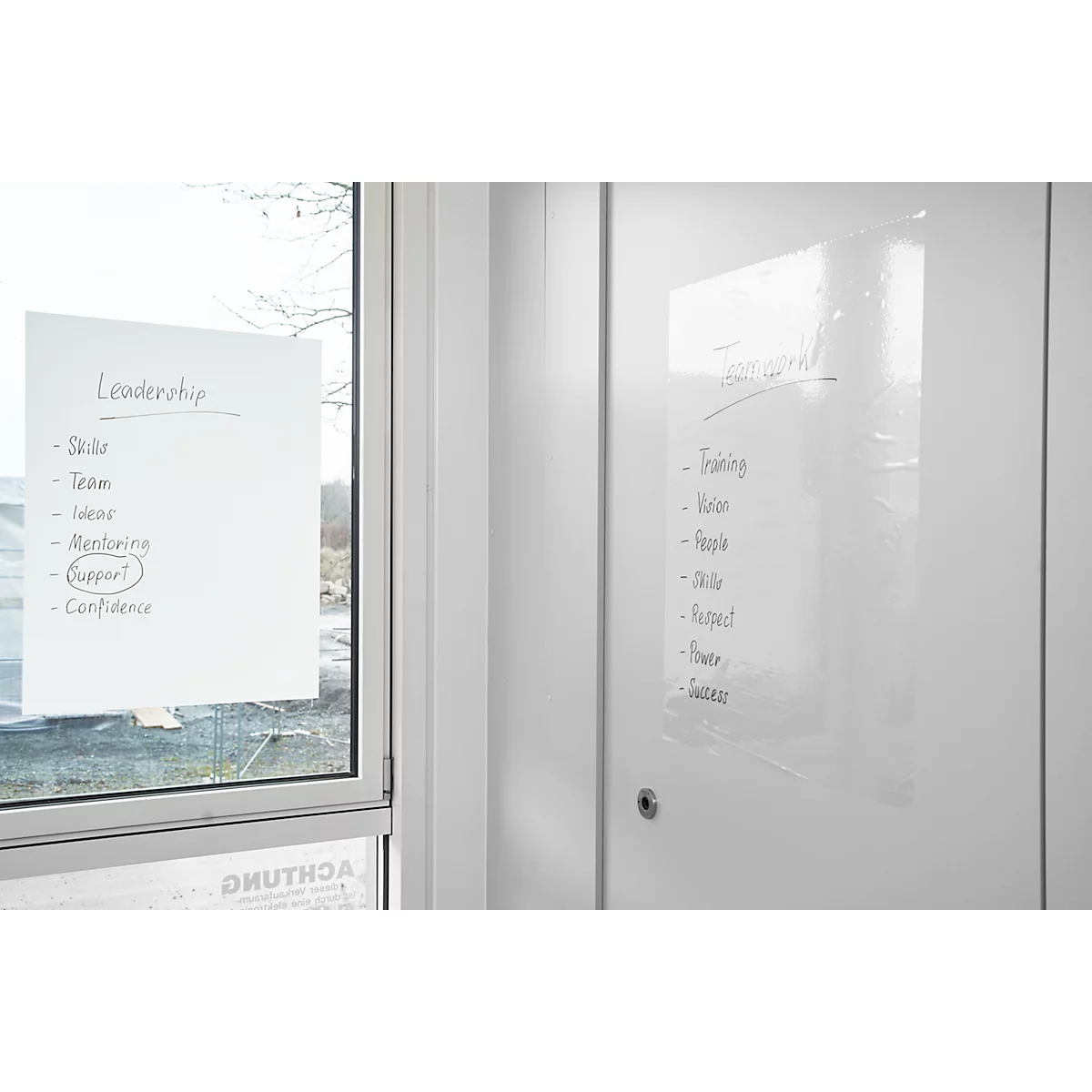Zwei weiße Zettel mit handschriftlichen Stichpunkten an einer weißen Tür und einem Fenster.