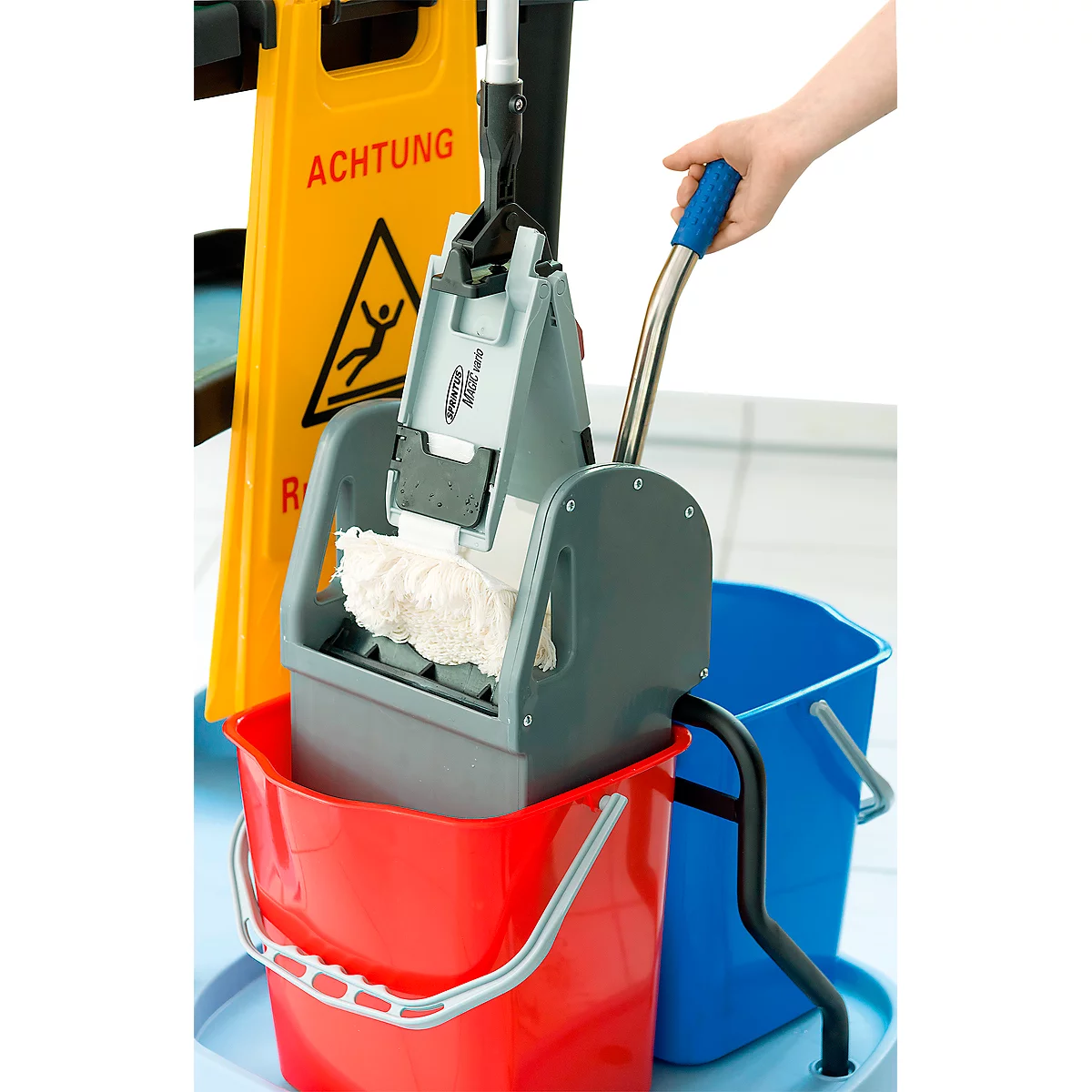 Cleaning cart with buckets, mop, and yellow "Caution Slippery" sign. A hand holds the mop handle.