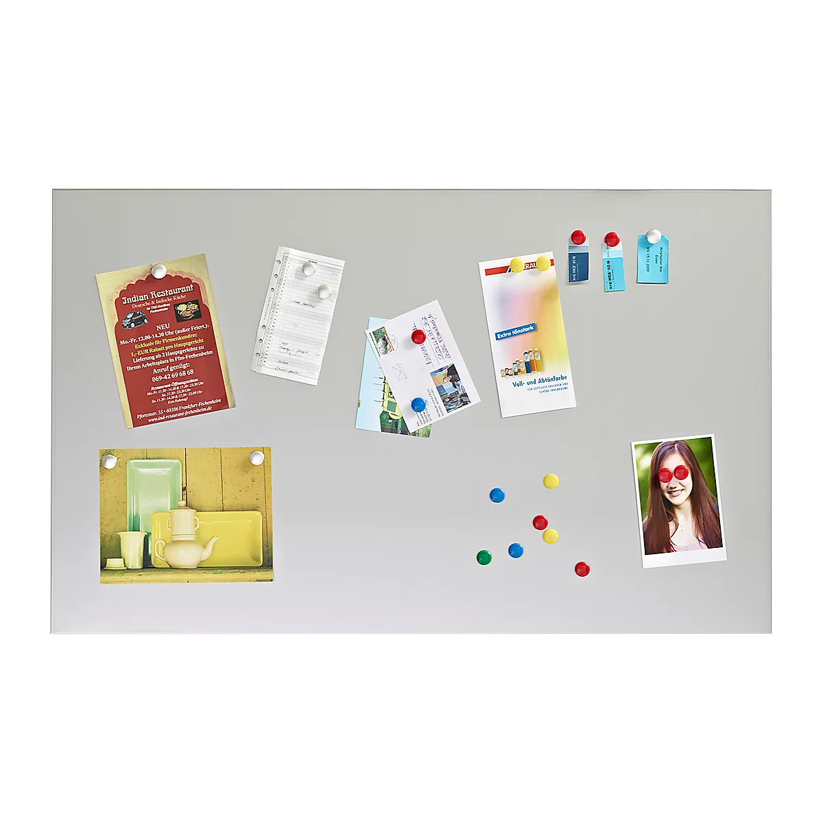 A magnetic notice board with notes, photos and colorful magnets. Invitations, restaurant advertisements and a photo of a smiling woman.