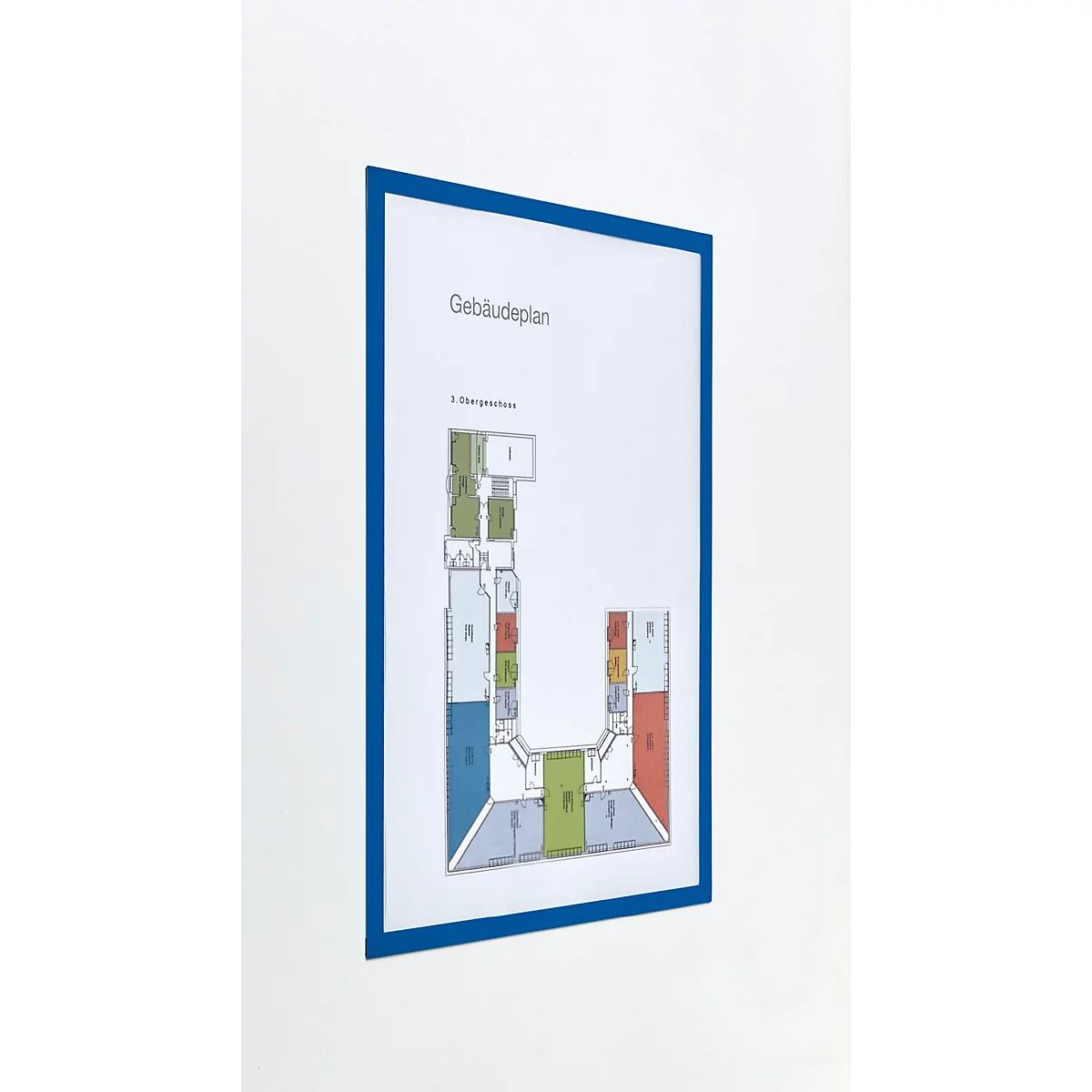 Ein Gebäudeplan in einem blauen Rahmen an einer weißen Wand.