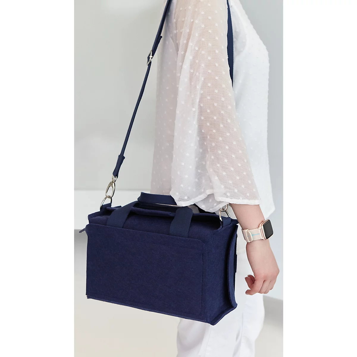 Frau trägt eine dunkelblaue, leichte Moderatorentasche von magnetoplan mit Schultergurt und zwei Tragegriffen.