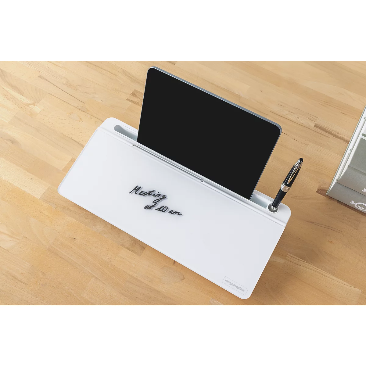 Weiße Whiteboard-Tischablage mit Tablet-Halterung, Stift und Notiz auf hellem Holztisch.