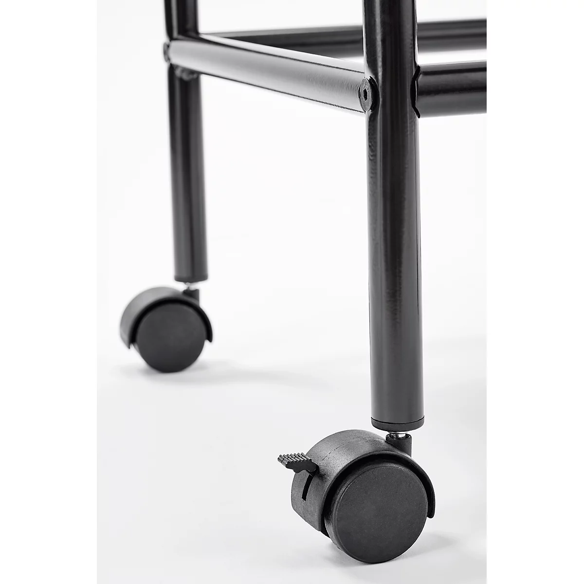 Close-up of two black furniture casters against a white backdrop.