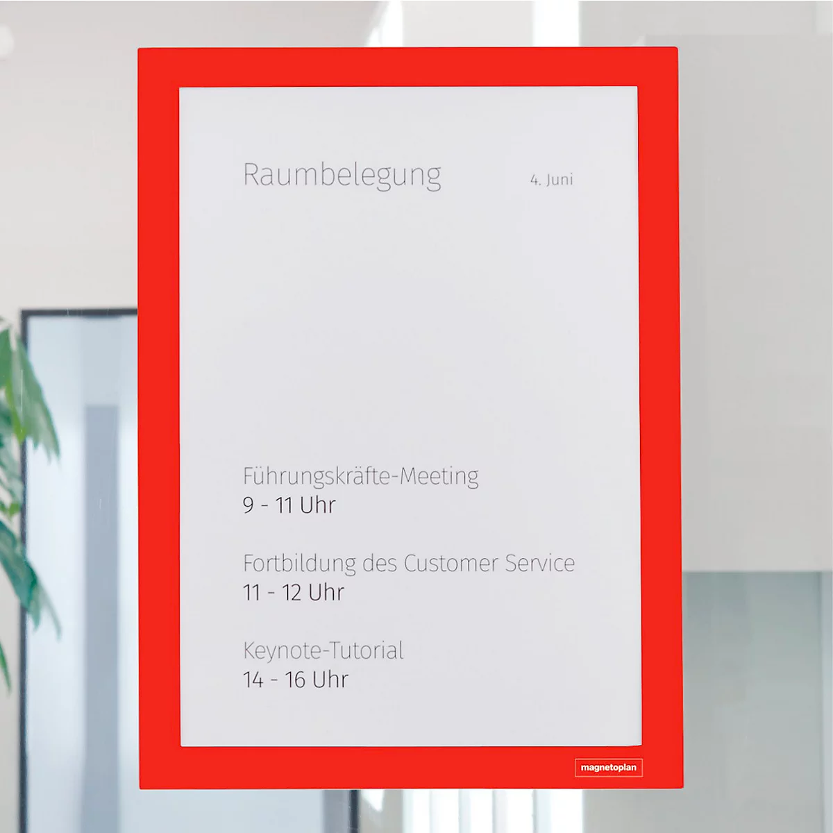 Roter Informationsrahmen an einer Bürowand mit dem Text Raumbelegung und diversen Meeting-Terminen.
